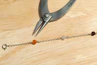 天然石ビーズ、ひとつひとつのビーズにゴムを通します