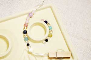 天然石ビーズにていねいにゴムを通します